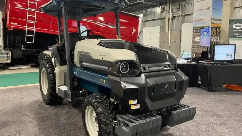 Monarch electric autonomous tractor on display at an indoor agricultural trade show exhibition floor